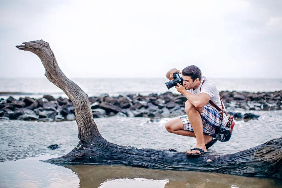 Vitor Lindo composing a photograph beside the water